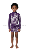 Girl wearing long-sleeve swimwear with purple hammerhead shark print