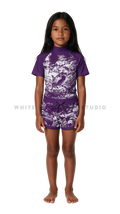 Girl wearing short-sleeve swimwear with purple hammerhead shark print